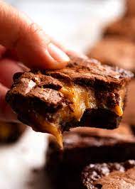Hand Holding Caramel Brownies In 2021 Spring Baking Dessert Recipes Recipetin Eats