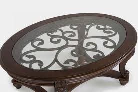Swirls of metal accents under a beveled glass inset tabletop add lovely dimension to your room. Norcastle Oval Cocktail Table By Ashley Furniture Texas Furniture Hut