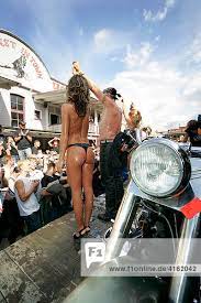 Frauen präsentieren sich nackt auf einer Harley Davidson. Bikewash, Harley  Davidson stampede, Westernstadt Eging am See Pressetermin , Passau, Bayern,  Deutschland.