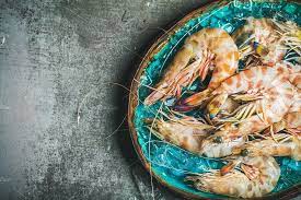 raw uncooked tiger prawns blue ceramic tray gray background blue ceramics