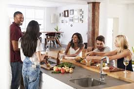 Hungry guests are difficult to keep happy especially if food is promised in advance through an invitation or by word of mouth. Friends Prepare And Serve Food For Dinner Party At Home Together Stock Photo Image Of Meal Celebrating 99963270