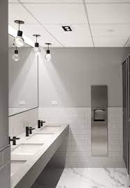 The rough brick wall and unfinished wood table of this space contrast with the smooth, geometrical look of the washbasin and mirror. Public Washroom Studio Alyse Office Bathroom Design Commercial Bathroom Designs Washroom Design