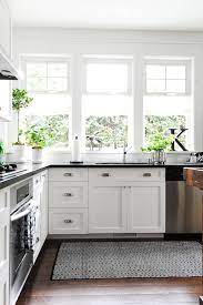 Black And White Kitchen Features White Shaker Cabinets Accented With Cup Pulls And Topped With Black Countert Home Kitchens Kitchen Design Kitchen Inspirations