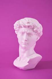 Copia de la cabeza de una estatua antigua de David en luz de neón rosa  sobre un fondo morado colores de tendencia