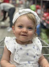 This cutie is my granddaughter. She is sitting in a supermarket trolly. I  cropped the trolly handle out of the picture. Can someone make the  background pretty please. I want to get