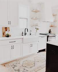 Black knobs and pulls give the bright white cabinets a pop of contrast. White Kitchen Black Hardware Hmdcrtn