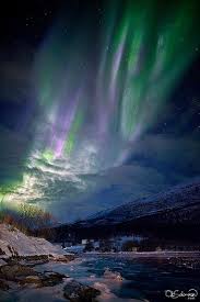 a beautiful aurora shines through snow and clouds to create quite the vibrant burst of color northern lights aurora borealis northern lights beautiful nature pinterest