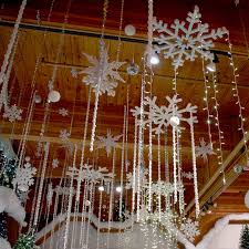 Snowflakes And Twinkling Lights Hang From The Ceiling Above Bronner S Christmas Ceiling Decorations Winter Wonderland Decorations Office Christmas Decorations
