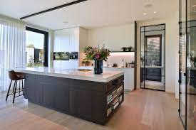 pivotdeur in luxe keuken binnenkijken in luxe villa stalendeurenhuys stalen deuren keuken met kookeiland moderne keukens