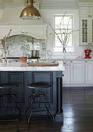 Choosing a black and white color palette is an excellent way to bring definition to an open kitchen without limiting the usable space. White Kitchen Black Island Brass Pendant Blue Kitchen Island Kitchen Inspirations Home Decor