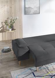 Canape D Angle Convertible Deplie Pour Faire Un Lit Deux Places De Couleur Gris Fonce Avec Quelques Canape Angle Convertible Canape Angle Table Bout De Canape