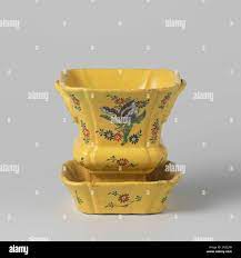 Subdated of multi-colored painted faience. Flower pot of multicolored  faience on a yellow fond. The flowerpot consists of a vase and a dish in  Louis XVDE style. The flower pot and the