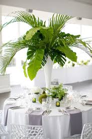 A Tall Cylinder Vase Spilling With Large Green Monstera Leaves And Palm Fronds Sur Tall Vase Arrangements Contemporary Wedding Inspiration Contemporary Wedding