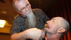 Volunteers shave their heads to show their support for cancer patients