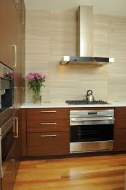 White iridescent, arabesque cooktop tiles layered on white subway tile, add a subtle yet contemporary design in a white kitchen. Explore Backsplash Ideas