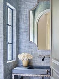 A Gray Framed Mirror Hangs From A Wall Clad In Blue Textured Wallpaper Over A Hammered Bathroom Remodel Small Budget Small Bathroom Remodel Bathroom Wallpaper