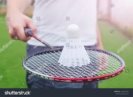 Badminton Racket In The Hand Of A Man In A White T Shirt On The Racket Lies A Shuttlecock In The Background Shirts Federball Schlage