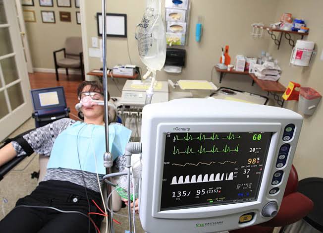 Intravenous (IV) conscious sedation creates a deeply relaxed state while specialized medical monitors track your vital signs continuously for absolute safety., AI generated