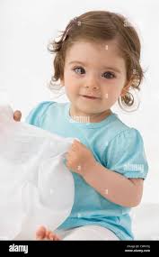Baby girl holding napkin, smiling, portrait Stock Photo