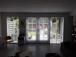 en pui met tuindeuren voorzien van witte houten jaloezieen met een wit ladderband jaloezieen houten jaloezieen witte houten jaloezieen