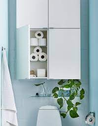 Four Simple White Cabinets And A Small Glass Shelf Displaying Plants Sit Above A Toilet Bathroom Wall Storage Ikea Wall Storage Small Bathroom Storage
