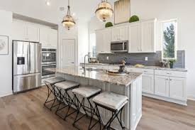 Sarasota Kitchen With Island White Cabinets Hardwood Floors And Gray Backsplash Kitchen Flooring Kitchen Table Decor Best Kitchen Countertops