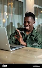 Handsome african american man using computer and smiling. Online video chat  with friends Stock Photo - Alamy
