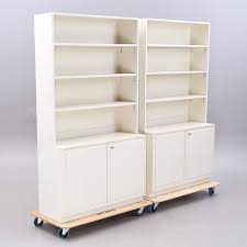 Arrange a pair of hardwood bookcases next to the living room mantle for a classic look, and coordinate with nearby wood furniture such as desks and coffee tables. Book Shelves With Cabinets 2 Sections Second Half Of The 20th Century Furniture Cupboards Shelves Auctionet