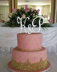A 2 Tier Pink And Gold Wedding Cake With Monogram Topper Pink And Gold Wedding Gold Wedding Cake Wedding Cake Toppers
