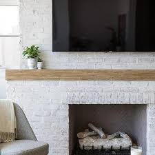 Instead of merely painted the fireplace with one color, the owners decided to turn it into an accent wall with a geometric design on it. White Brick Fireplace Design Ideas