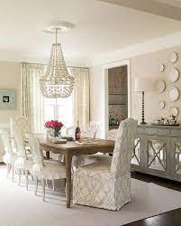 Modern skirted dining room chair with loose cushions and wheels. Gray Mirrored Sideboard Under Decorative Wall Plates Transitional Dining Room