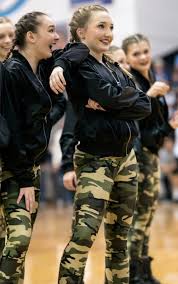At the end of the routine freshmen Katie Reda and Elle Vuillemin pose  facing the student sections. Photo by Lucy Morantz