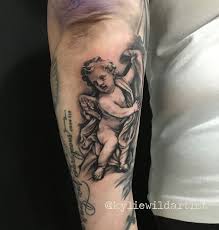 What is the meaning of cherub? Little Cherub Tattoo On Back Of Forearm Black And Grey By Kylie Wild Heslop Artist Www Artgonewild Com Au Cherub Tattoo Cherub Tattoo Designs Tattoos