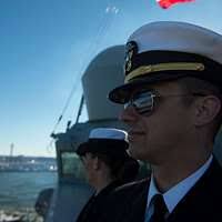 Seaman Jocelyn Ramey uses the ship's binoculars while standing watch as a  lookout aboard the Arleigh Burke-class guided-missile destroyer USS Mason  (DDG 87) while transiting the Strait of Hormuz.
