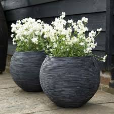 Our first outdoor planter idea comes to us from i love this because you can easily change out plants, and even combine plants with different watering. Round Ball Fiberstone Ribbed Black Planter By Cadix Capi Nature D62 H48 Cm Large 145 Ltrs Cap From 155 65 Getpotted Com Large Outdoor Planters Large Garden Pots Large Garden Planters