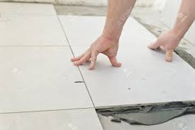Tile comes in a variety of styles, colors and the best way to ensure square lines is to make a floor plan by drawing the walls of the room as accurately as possible on a sheet of grid paper. Laying Ceramic Tiles Troweling Mortar Onto A Concrete Floor In Preparation For Laying White Floor Tile Stock Photo Picture And Royalty Free Image Image 24261225