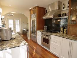 Gold oak wooden kitchen island finished with white quartz surrounded by gray wash oak wood floors and light gray shaker cabinets. Two Tone Brown Kitchen Cabinets Novocom Top