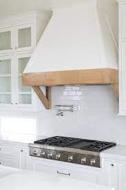 Gorgeous Kitchen Features A White French Hood With A Rustic Wood Trim And Brackets Fixed Between Glass Kitchen Inspirations Kitchen Remodel Kitchen Range Hood