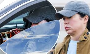 Twin Peaks vet Lara Flynn Boyle sips whisky in her car