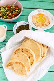 A Partially Covered Pile Of Scattered Homemade Easy Pita Bread Surrounded By Salad Hummus Tahini Pita Bread Recipe Cold Coffee Recipes Bread Recipes Homemade