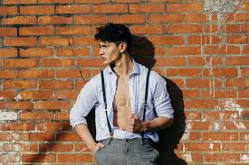 If placed too low, it can leave too much of the chest exposed when it shouldn't be. Man In Unbutton Shirt Leaning On Wall And Looking Aside Outdoors Looking Away Stock Photo 185125794