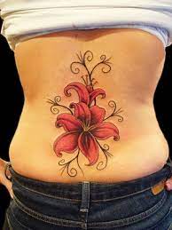 Entre la masse fesseuse et le commencement du dos, des branches d'arbres à fleurs, des envolées de papillon, des cœurs fléchés, des motifs tribaux aux. Jolie Fleur Tatouage Bas Du Dos Femme