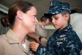 Chief (select) Legalman Erica Keels is pinned to the rank of chief petty  officer by her 6-year-old son during a chief pinning ceremony