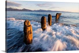 Paddle boarders and skim boarders are also silhouetted. Surf Rushing Around Old Pilings Along Beach Homer Spit Kachemak Bay Alaska Wall Art Canvas Prints Framed Prints Wall Peels Great Big Canvas