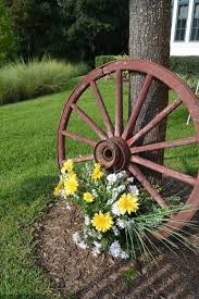16 Magnificent Ways To Use Old Wagon Wheels In Your Garden The Art In Life Rustic Garden Decor Wagon Wheel Garden Wagon Wheel Decor