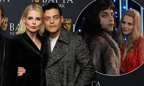 Rami malek wears a balenciaga checked coat with a shirt, boots, and sweater vest by gucci. Rami Malek Cosies Up To Lucy Boynton At Bohemian Rhapsody Daily Mail Online