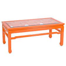 Its tempered glass top sits atop four sleek rounded legs, which in turn sit atop white manufactured wood legs, with a tempered glass lower shelf perfect for hosting extra magazines or coffee table books. Orange Lacquer Coffee Table With Beveled Glass Top Shopcandelabra Worldsaway Orange Table Coffee Table Table Painted Furniture