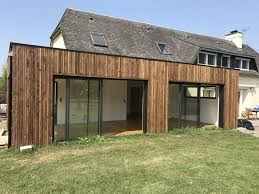 Quand la construction de l'extension toit plat est accolée à la maison existante, le chantier doit inclure l'intégration. Construction Ossature Bois Yoan Naturel