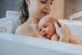 Ein kleiner Junge liegt auf der Brust seiner Mutter in der Badewanne zu  Hause, lizenzfreies Stockfoto