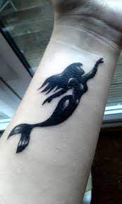 A mermaid tattoo is symbolic of having a free spirit and love for the sea. Black Ink Mermaid Tattoo On Wrist By Jenifer Hatton